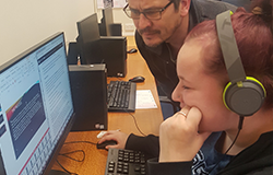 Yooung boy being taght on the computer by his teacher