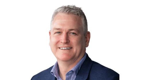 Headshot of James Lye. Portrait of a middle-aged man with short, silver hair, smiling at the camera. He is wearing a blue blazer over a checkered button-up shirt.