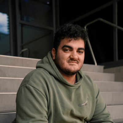 Young man wearing a grey hoodie sitting on concrete steps