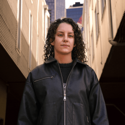young woman standing outside looking to camera