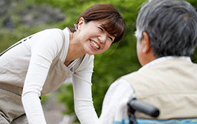 Female carer smiling at a man in a wheelchair