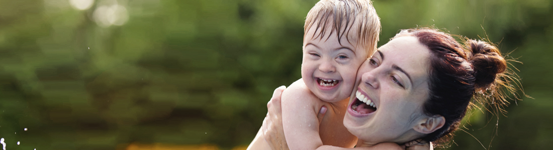 Young mum holding her baby boy close to her and smiling