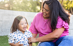 Mother wearing pink top holds onto her small son