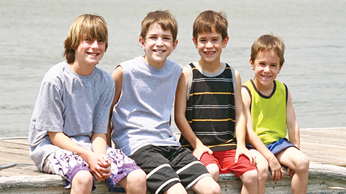 Four boys smiling at the camera, clients of MCM