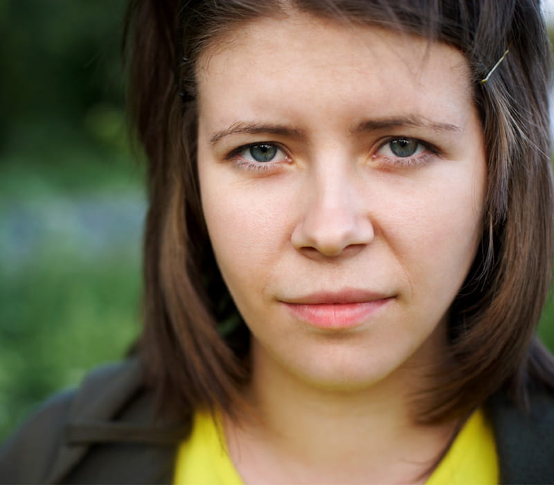 Teenage girl with short brown hair looking at the camera