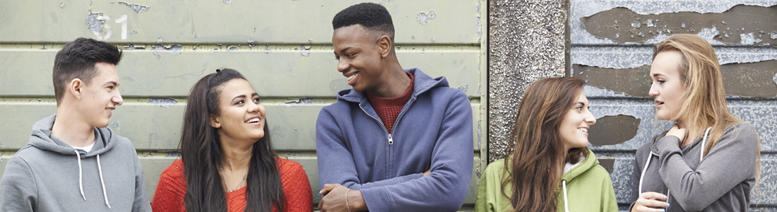 A group of young people talking and smiling