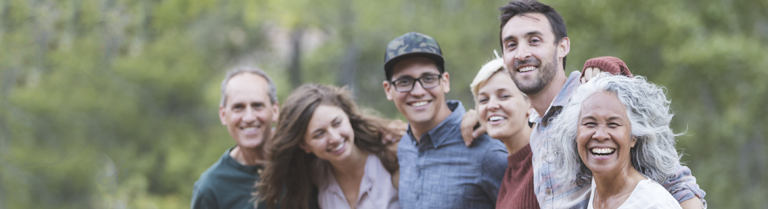 A group of people of various ages hugging and smiling