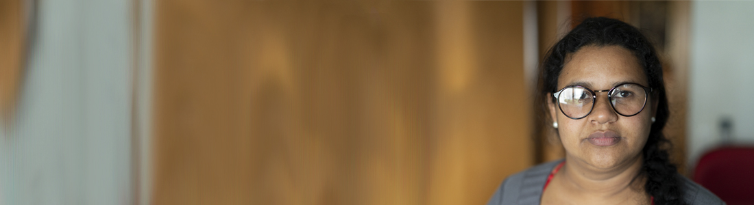 Lady of Asian descent wearing glasses and looking at the camera