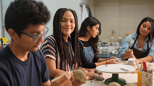 Group of four students participating in art activities