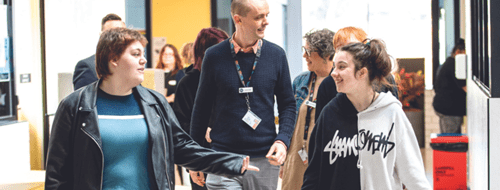 school with 2 female students talking to a teacher