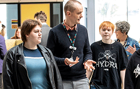 Students walk alongside their teacher