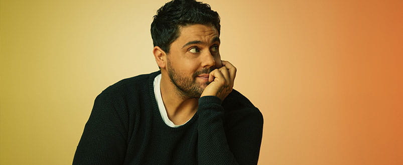 Dan Sultan wearing a black jumper, leaning on his arm