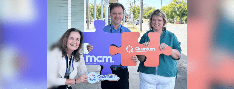 3 people holding giant puzzle pieces with the words mcm and quantum