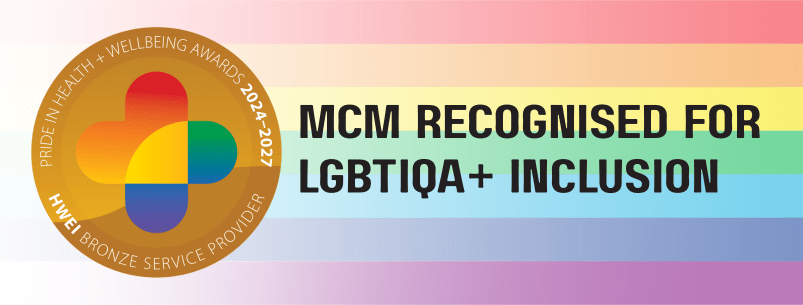 Banner featuring a Pride-themed background with rainbow stripes. A circular badge on the left reads “Pride in Health + Wellbeing Awards 2024–2027 – HWEI Bronze Service Provider.” Bold black text on the right reads “MCM Recognised for LGBTIQA+ Inclusion.”