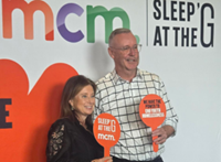 Nicole Brittain and Paul Wappet standing in front of MCM Sleep At The G wall