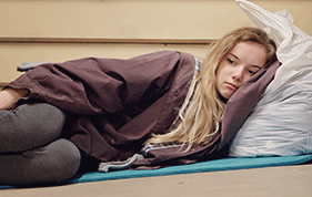 Young girl lying on the floor with her head against the pillow