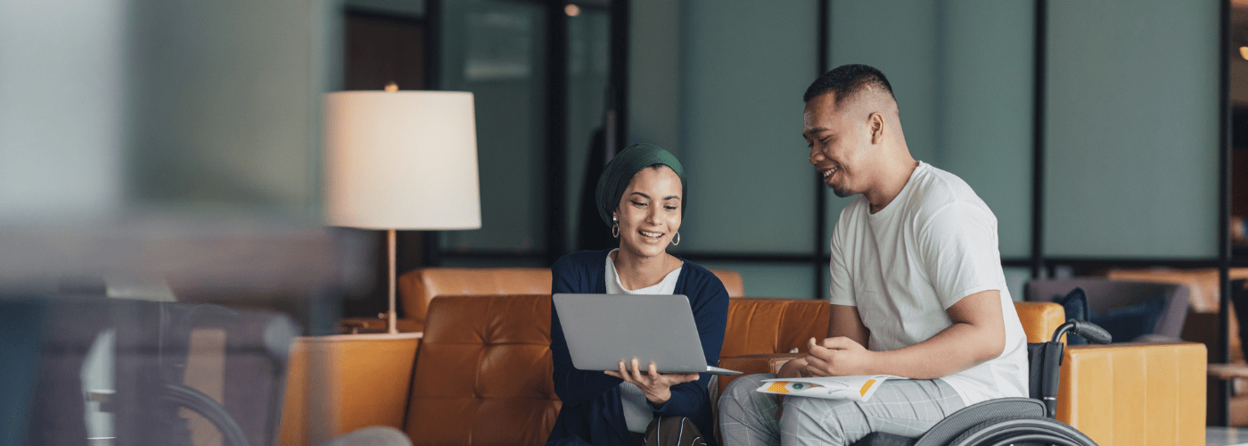 Man with disability in a wheelchair discussing work with a co worker