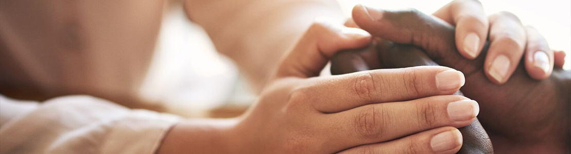 Two sets of hands clasped together