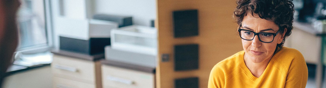 Photo of a woman in a yellow jumper.