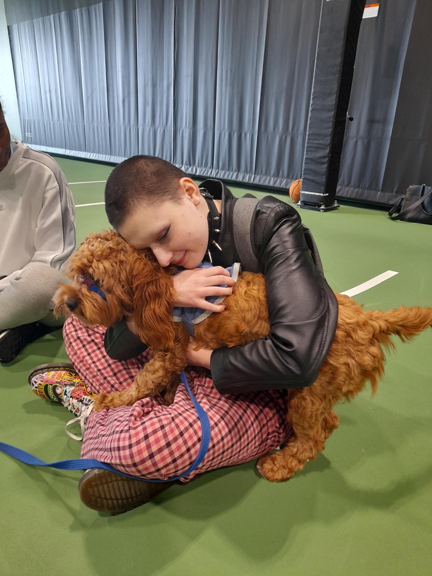 HHA staff cuddle Therapy Dog.