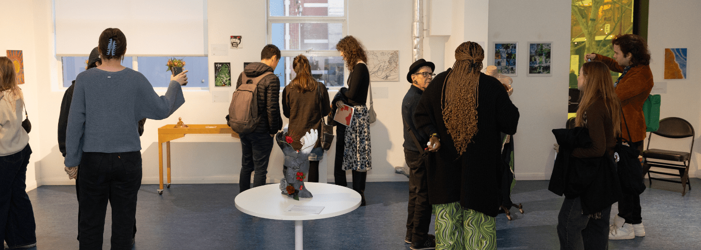 A crowd of people are viewing artwork displayed at MCM's What Matters Youth Homelessness Art Exhibition